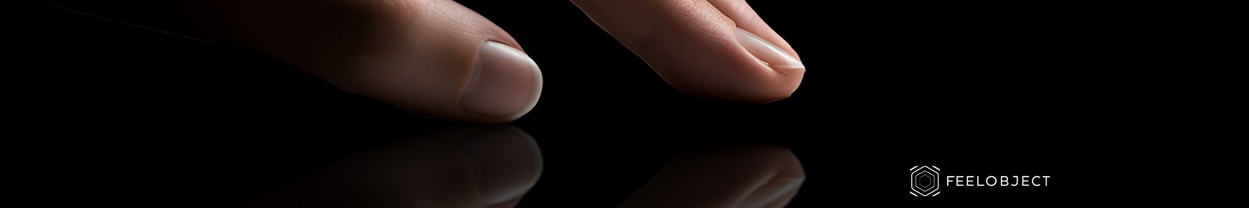 Une main de femme avec les doigts posés délicatement sur une surface en verre très noire ne laissant entevoir que le reflet de la main et un arrière plan noir. Le logo de Virtuoz et Feelobject sont présent avec une phrase : "La mobilité au bout des doigts"